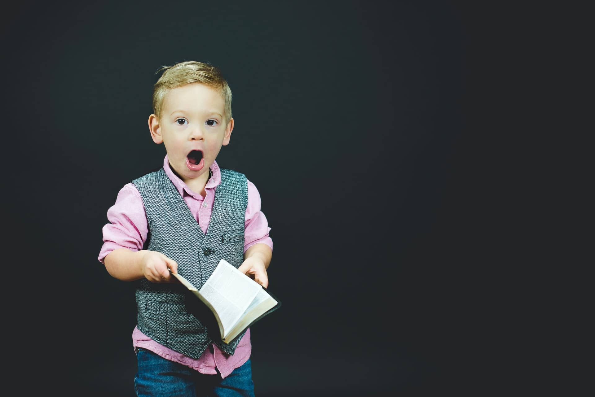 young boy with shocked expression and book in hand; SaaS Marketing Books concept